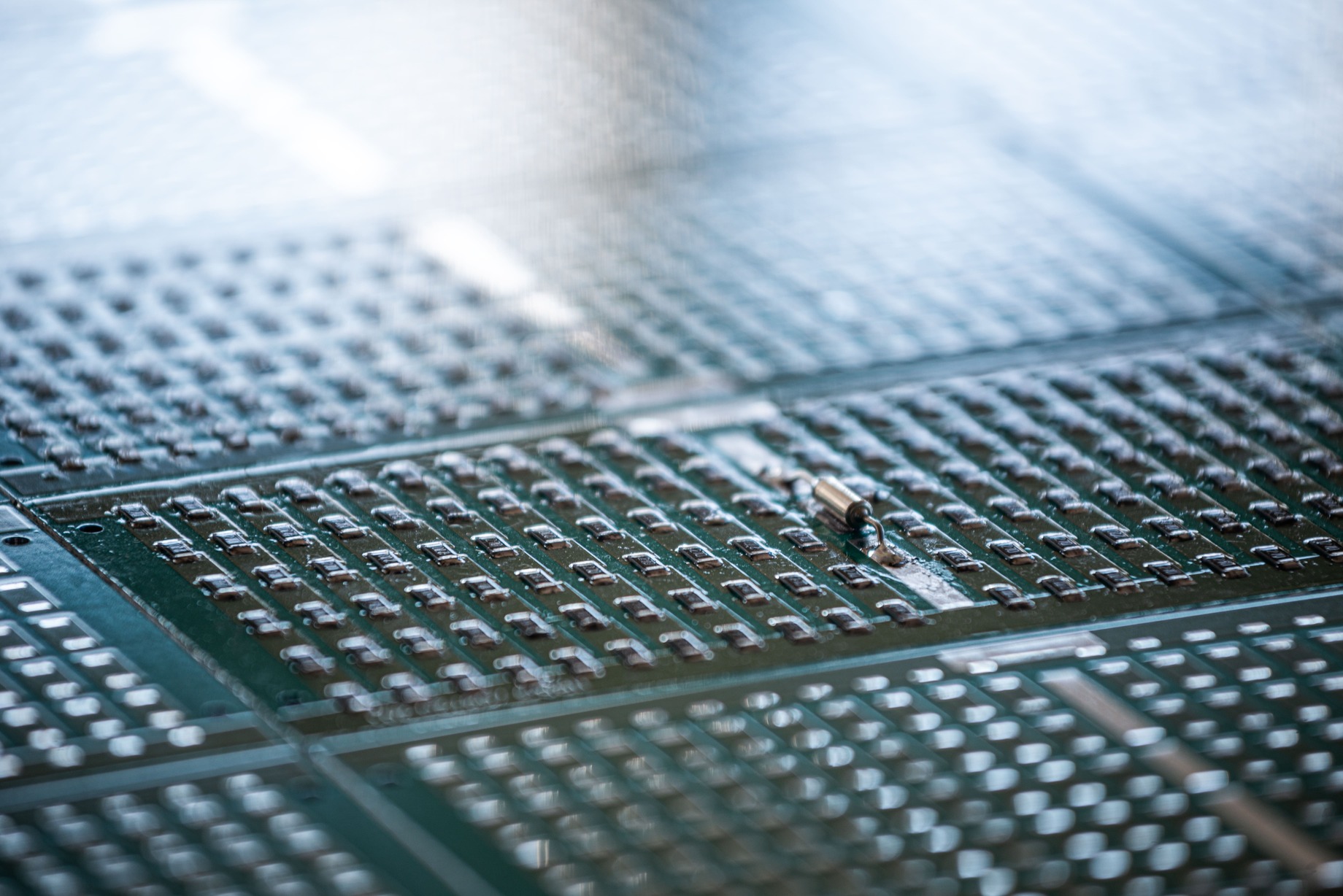 Nahaufnahme mehrerer grüner Leiterplatten mit zahlreichen kleinen elektronischen Bauteilen.