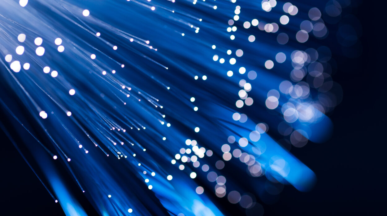Leuchtende, blaue Lichtfasern verlaufen strahlenförmig nach rechts unten. Die Endpunkte sind als helle Lichtpunkte sichtbar.