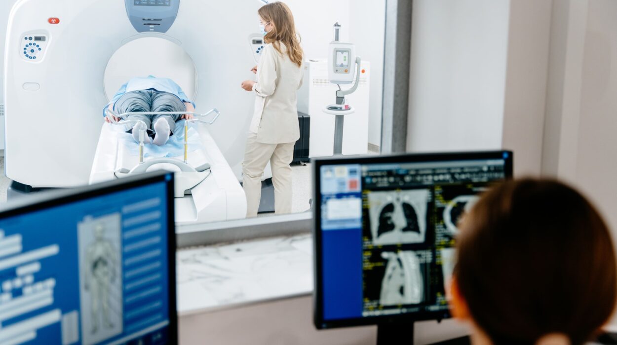 Patient liegt in CT-Röhre, medizinisches Personal daneben; im Vordergrund Monitore mit CT-Bildern.