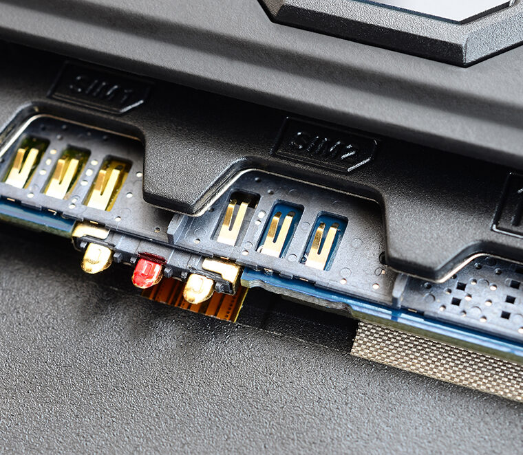 Nahaufnahme eines SIM-Karten- und Speicherkarten-Slots eines elektronischen Geräts. Sichtbar sind mehrere Steckplätze mit goldenen Kontakten, darunter zwei SIM-Schächte und ein SD-Kartenslot. Auch Antennenanschlüsse sind zu sehen.