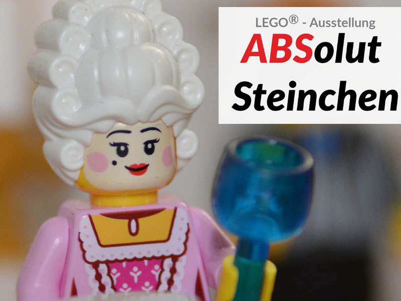 LEGO®-Figur einer adelig gekleideten Frau mit weißer Perücke und blauem Kelch. Rechts daneben Text: „LEGO®-Ausstellung ABSolut Steinchen“, wobei „ABS“ farblich hervorgehoben ist.