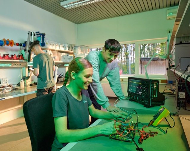 Junge Forschende arbeiten in einem Elektroniklabor an einer Schaltung – Praxisnahes Lernen mit moderner Messtechnik.