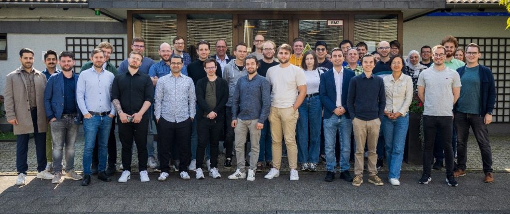 Teamfoto einer Forschungsgruppe. Alle Personen blicken in die Kamera und lächeln, was auf eine freundliche, kollegiale Atmosphäre hinweist.