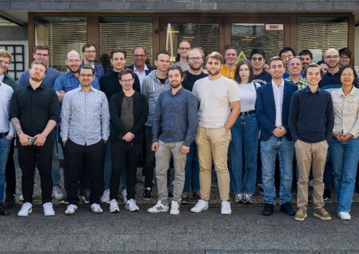 Teamfoto einer Forschungsgruppe. Alle Personen blicken in die Kamera und lächeln, was auf eine freundliche, kollegiale Atmosphäre hinweist.